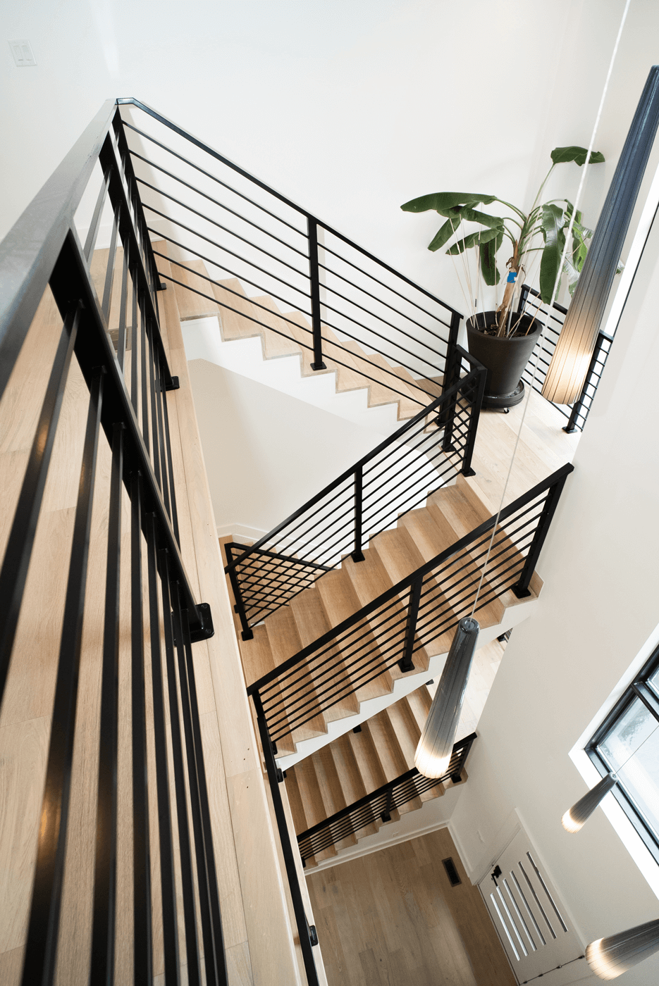 A downward view of custom modern railing throughout multiple levels of a home.
