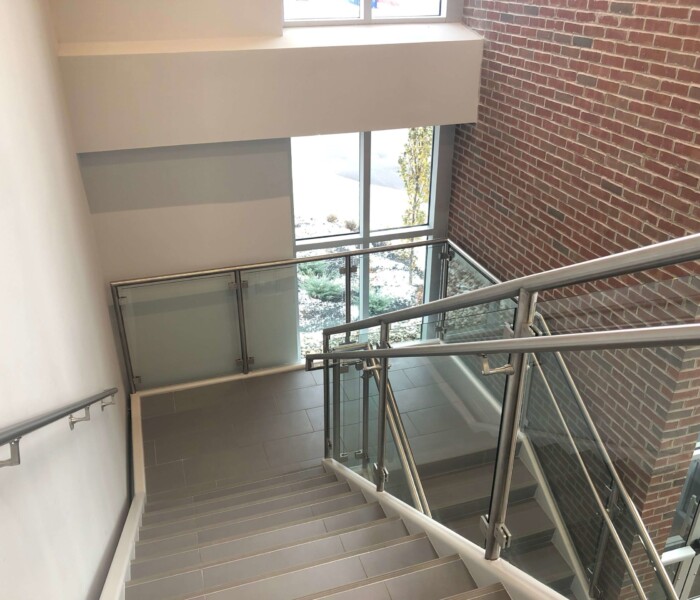Custom Stainless Steel and Interior Glass railing throughout a commercial project on stairs.