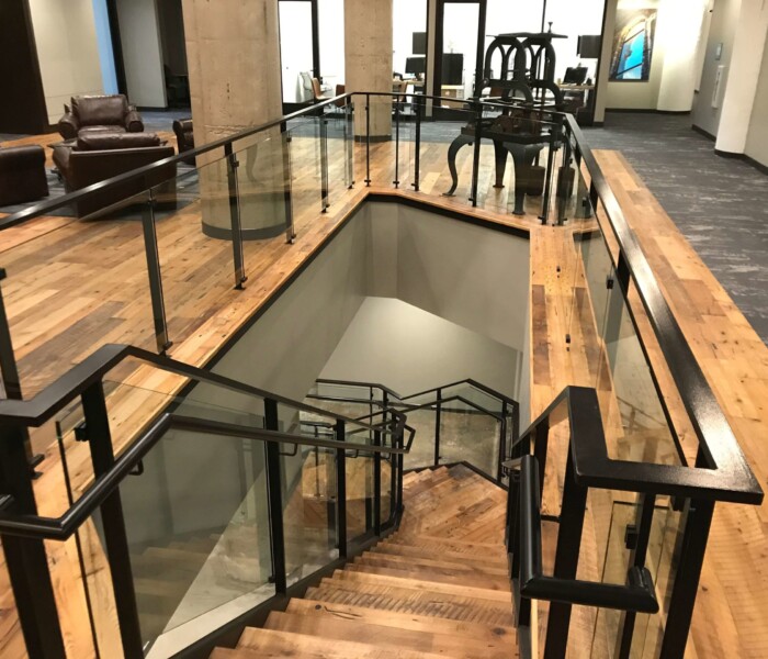 A downward view of the custom interior glass railing in a commercial building in Cincinnati.