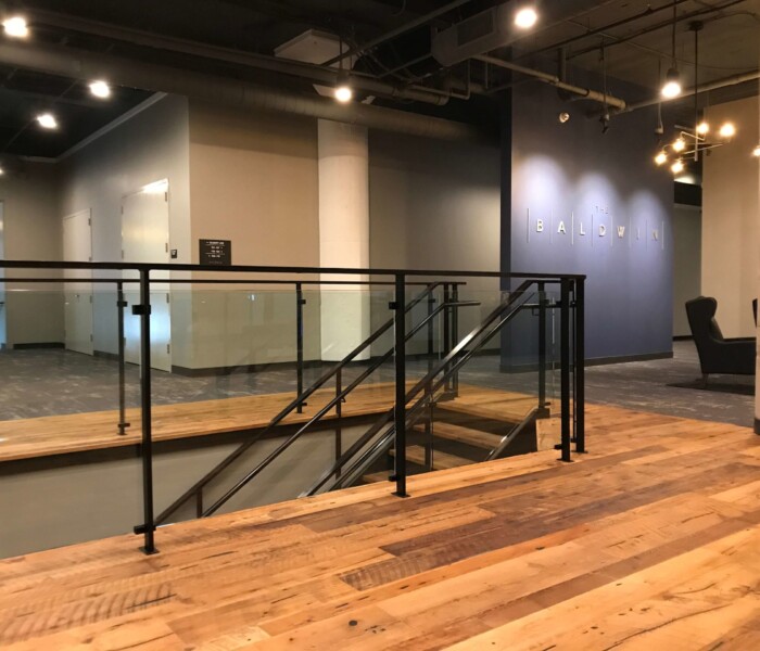 A view of The Baldwin with the architectural interior glass railing going down the stairs.